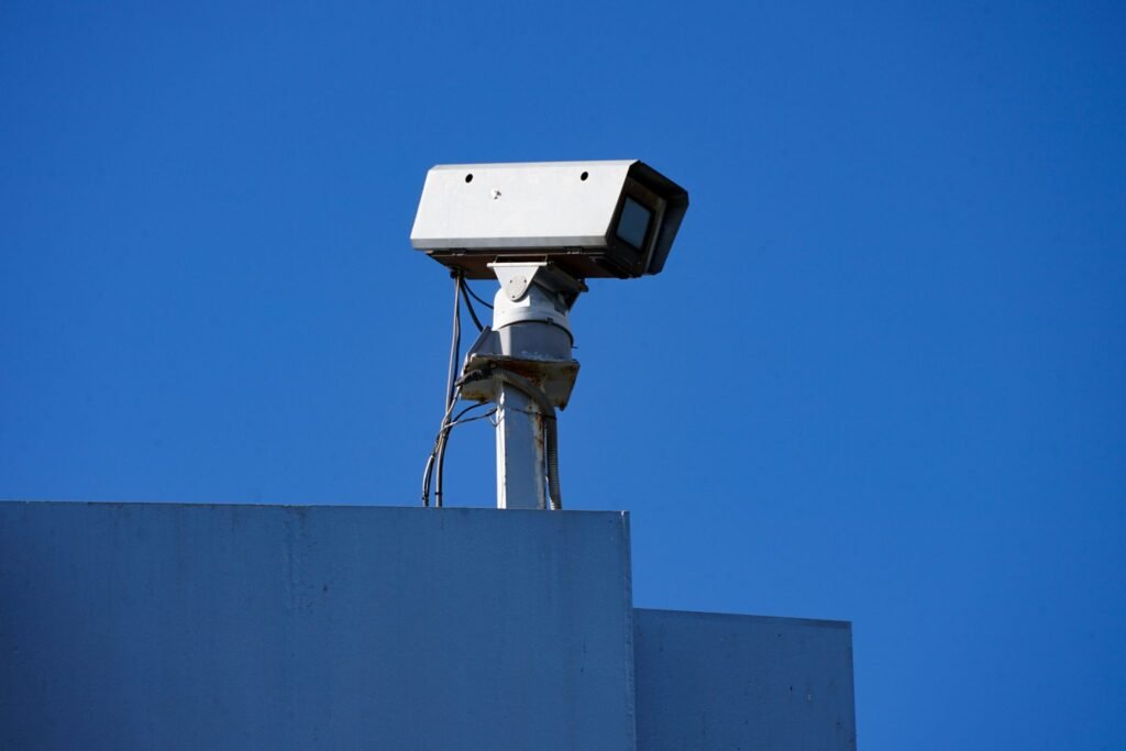 Commercial security camera mounted on a pole on top of a business building