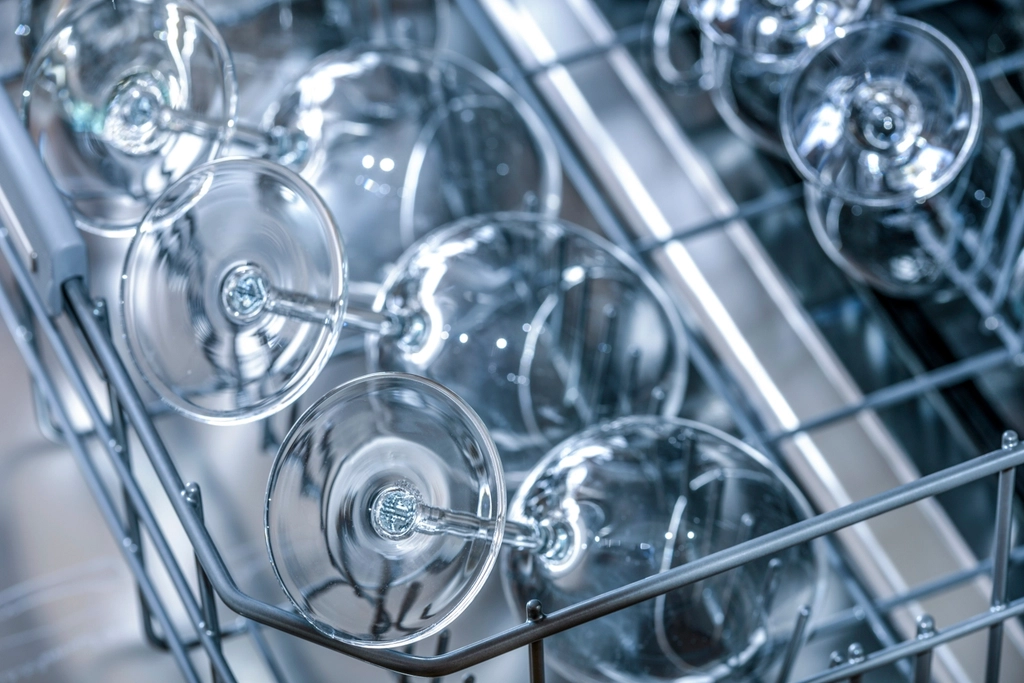 Clean wine glasses in the upper rack of a dishwasher