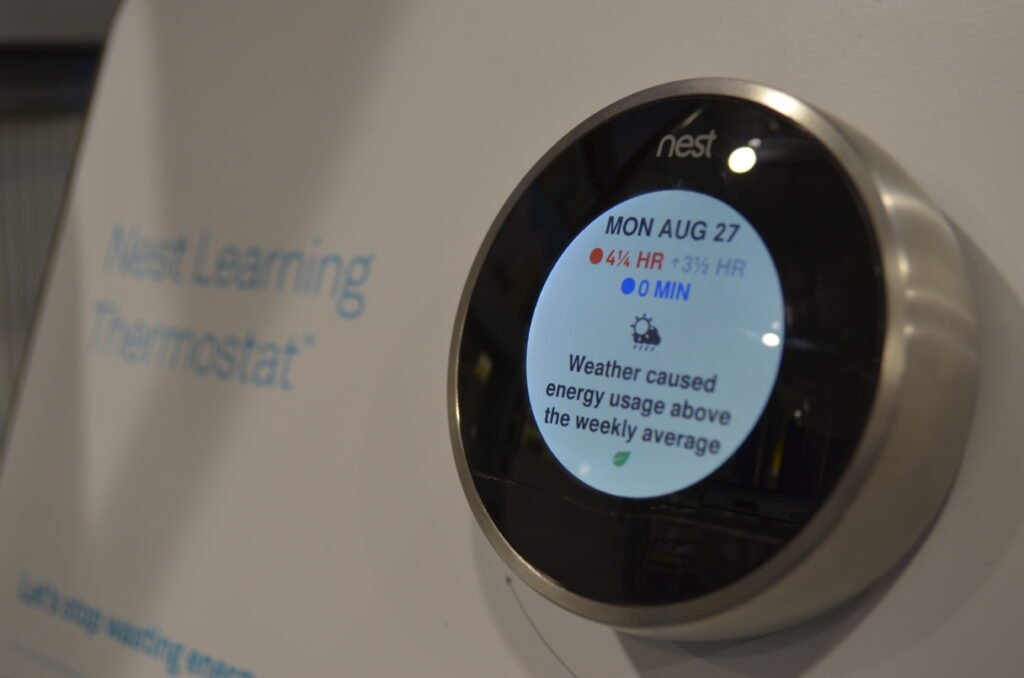 Nest Learning smart thermostat on a wall showing energy use